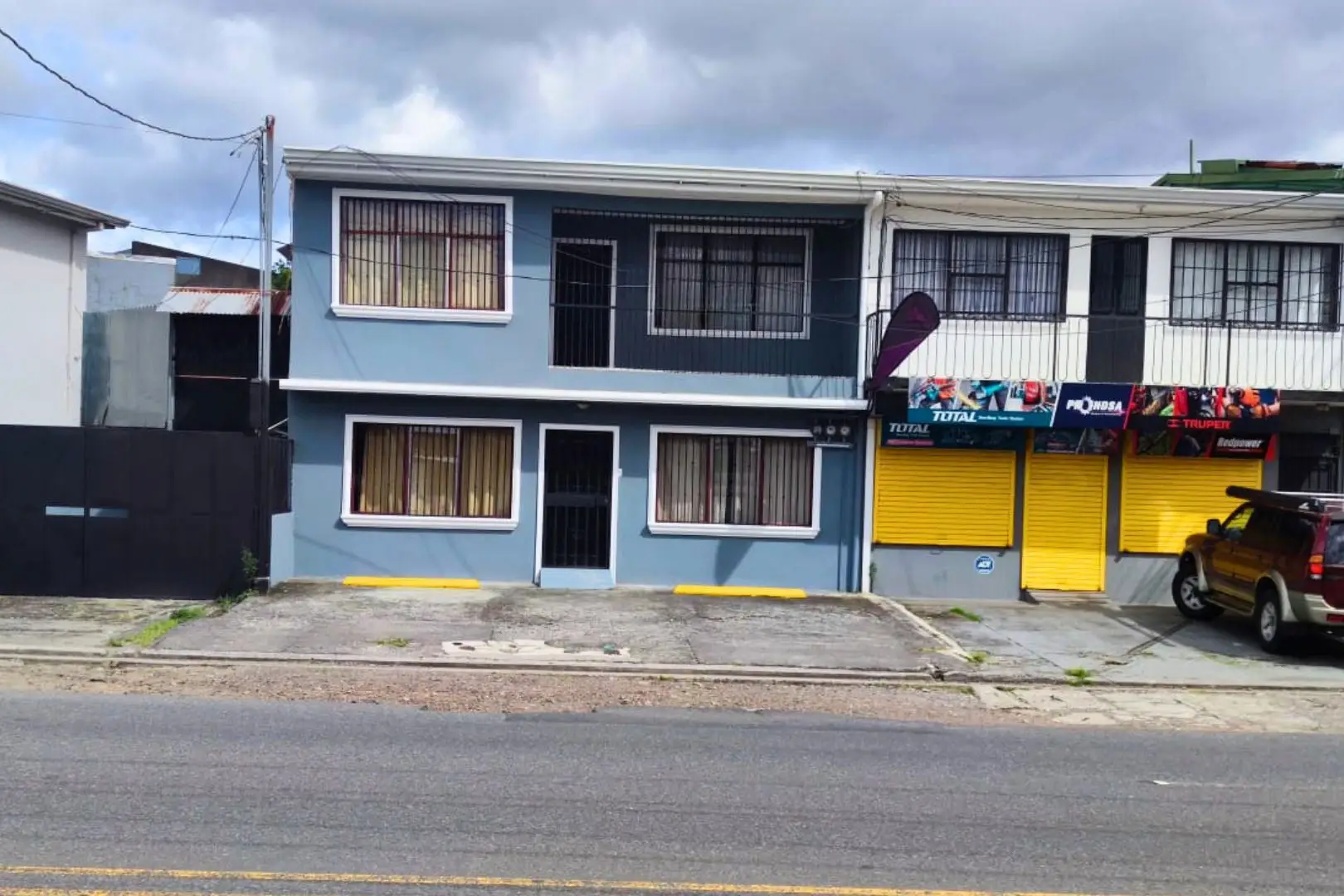 A blue building with two windows and a yellow door.