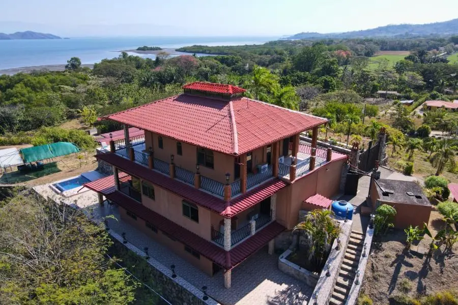 A large house with a red roof and a deck.