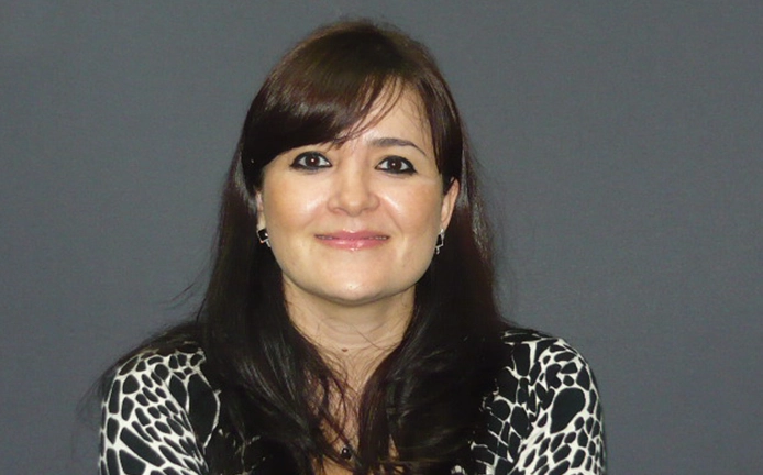 A woman with long hair and bangs wearing a leopard print shirt.