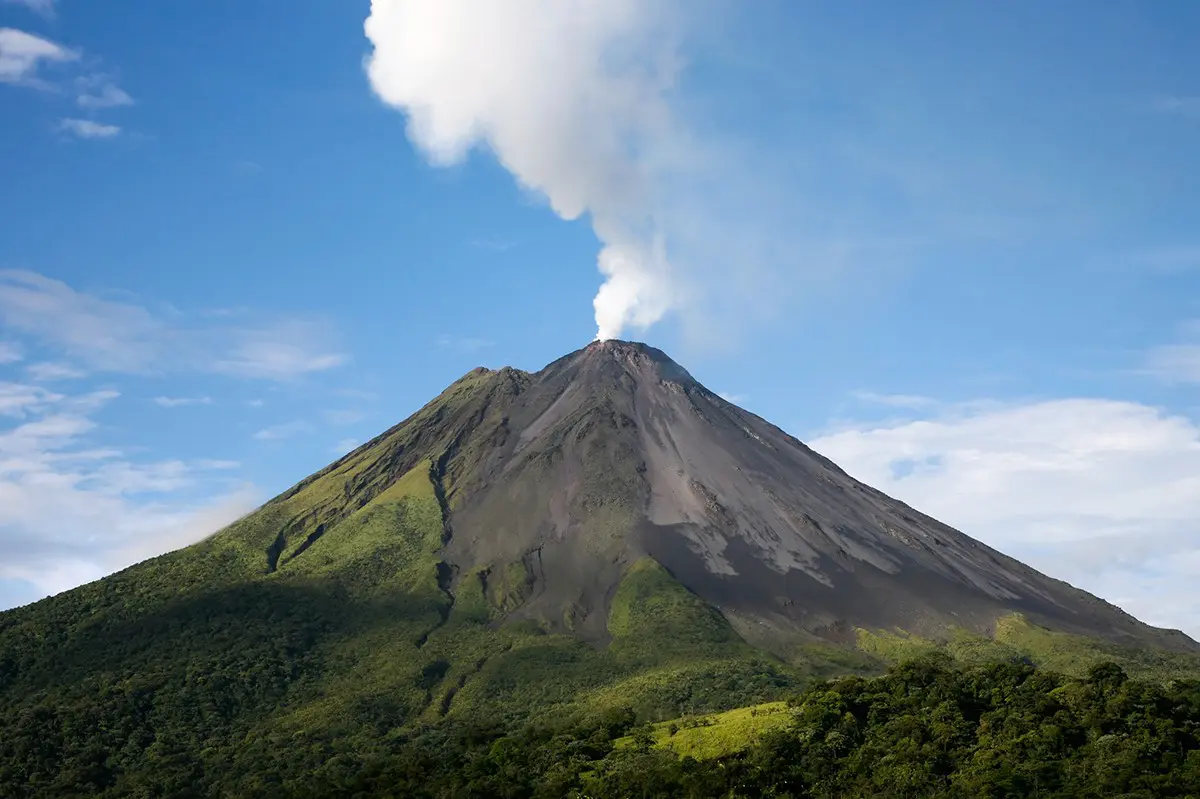 A very large mountain with smoke coming out of it.