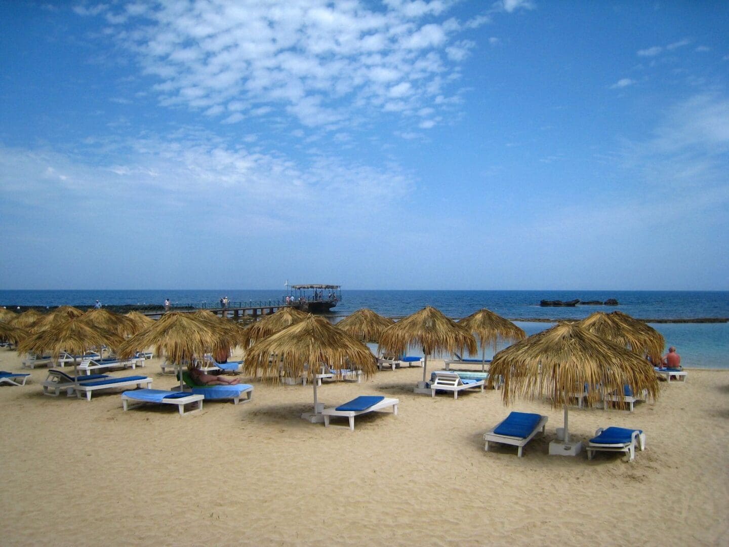 A beach with many chairs and umbrellas on it